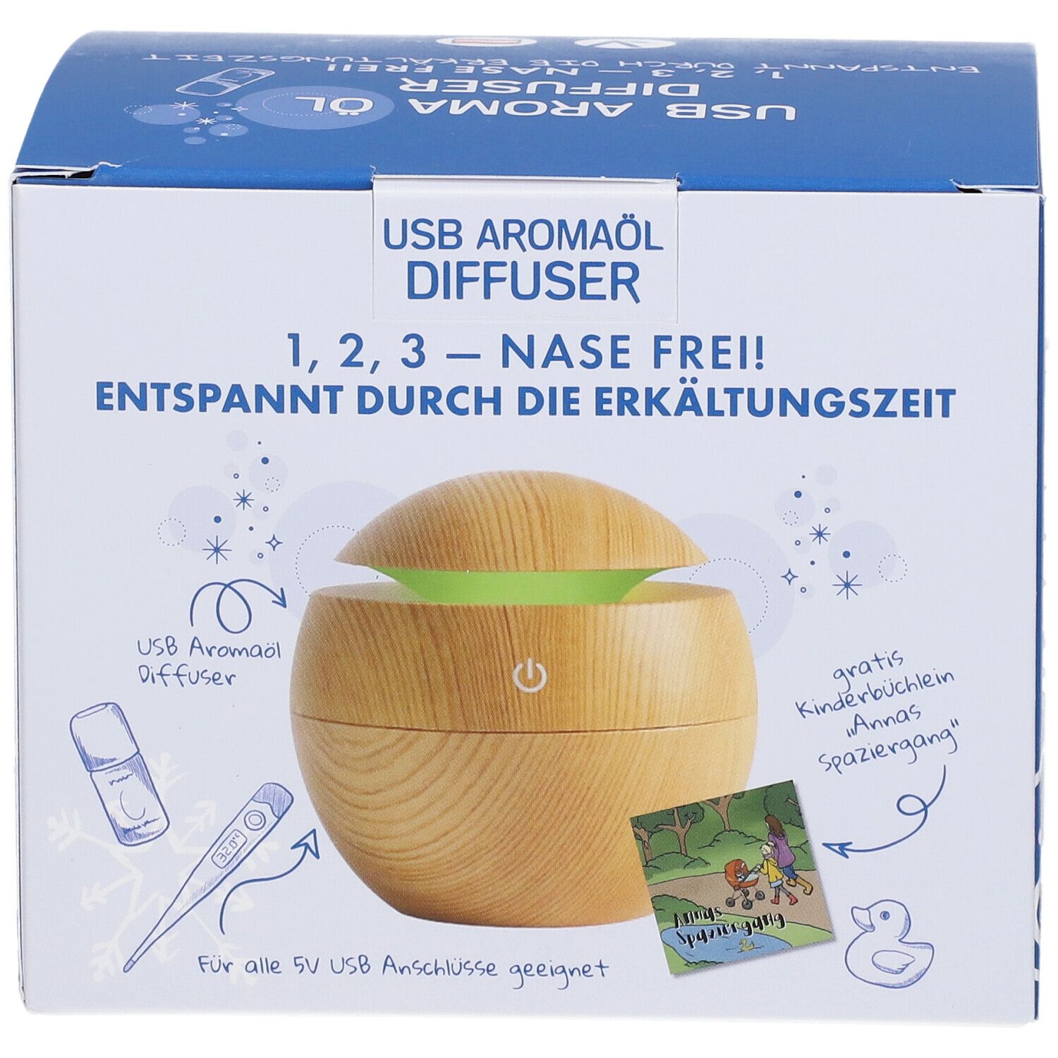 Emballage du produit. Inscription: USB Aromaöl Diffuser, 1,2,3 - Nase Frei! Illustration d'un diffuseur en bois avec lumière verte. Accessoires illustrés.