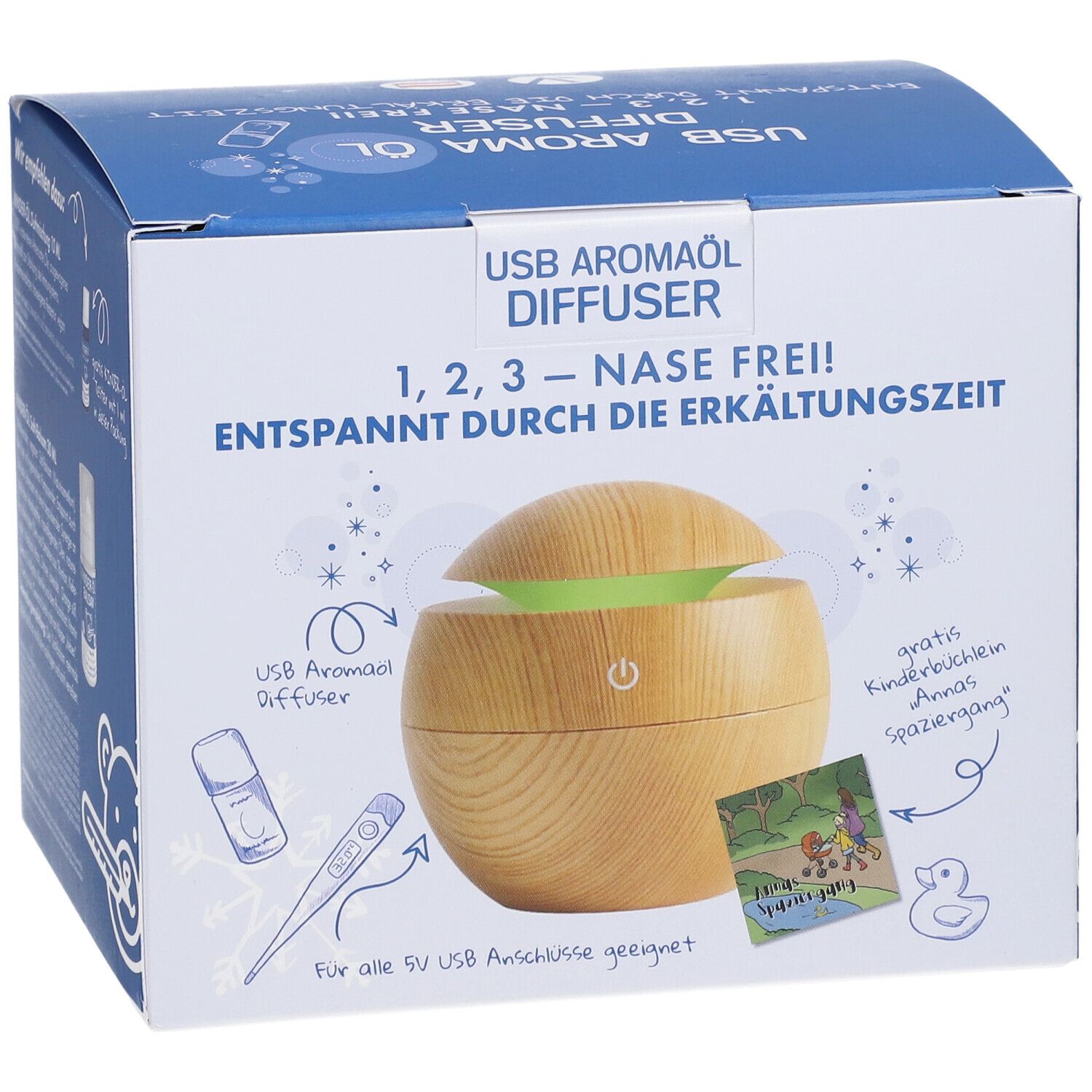 Emballage du produit. Inscription: USB Aromaöl Diffuser, 1,2,3 - Nase Frei! Illustration d'un diffuseur en bois avec lumière verte. Accessoires illustrés.