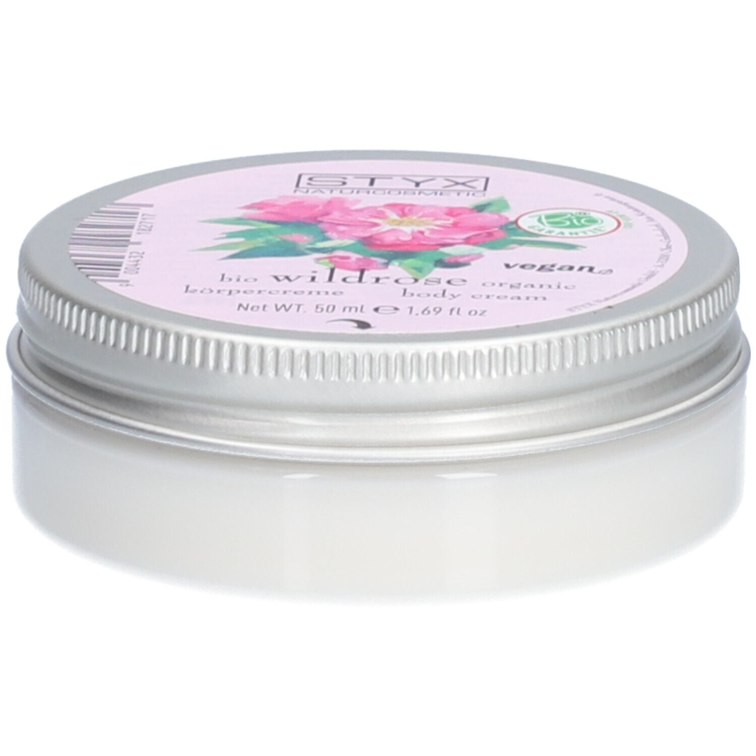 Pot de crème avec couvercle. Sur le couvercle : STYX Naturkosmetik, Wildrose, vegan. Étiquette rose avec fleurs de rose. Pot en métal.