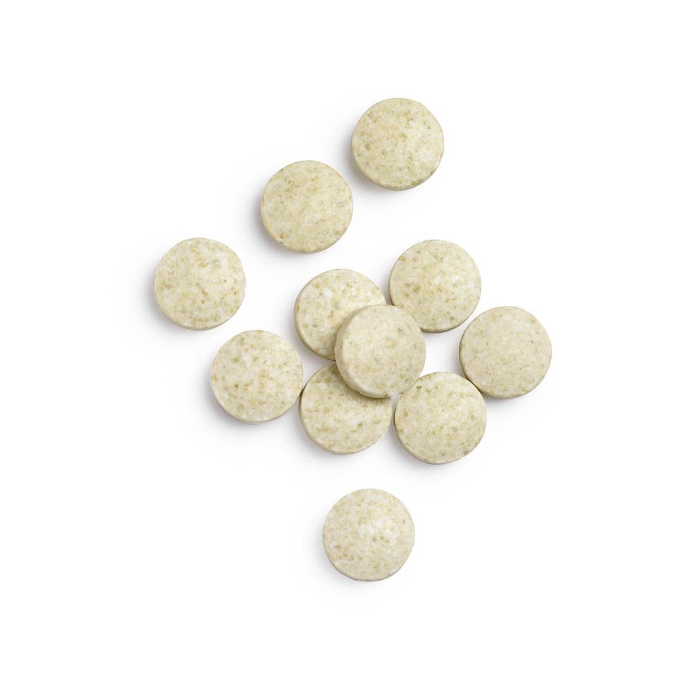 Comprimés. Comprimés ronds, verts. Sur fond blanc.