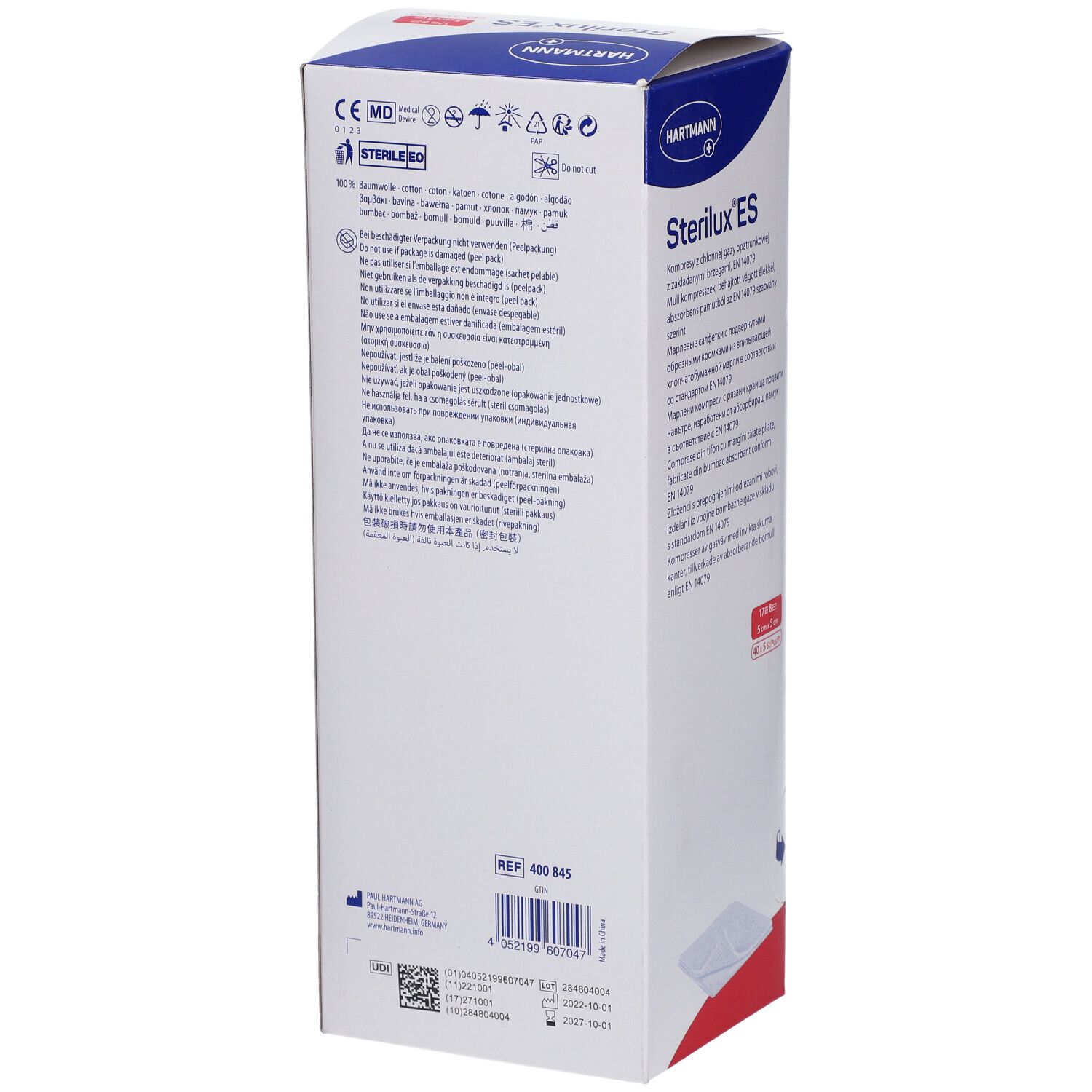 Emballage de Sterilux ES compresses. Boîte blanche avec texte bleu et rouge. Logo Hartmann. Texte multilingue.