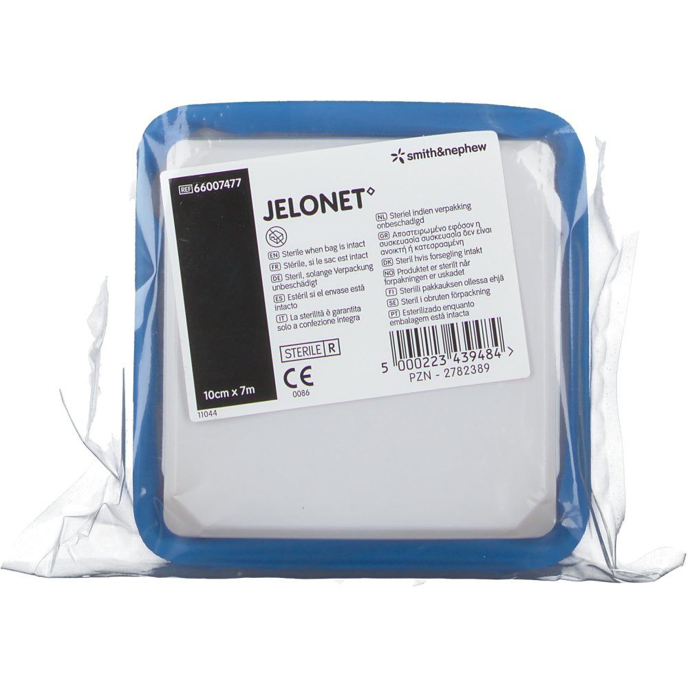 Compresse carrée dans un support bleu, emballée. Inscription : JELONET, 10cm x 7m, stérile. Marque Smith & Nephew.