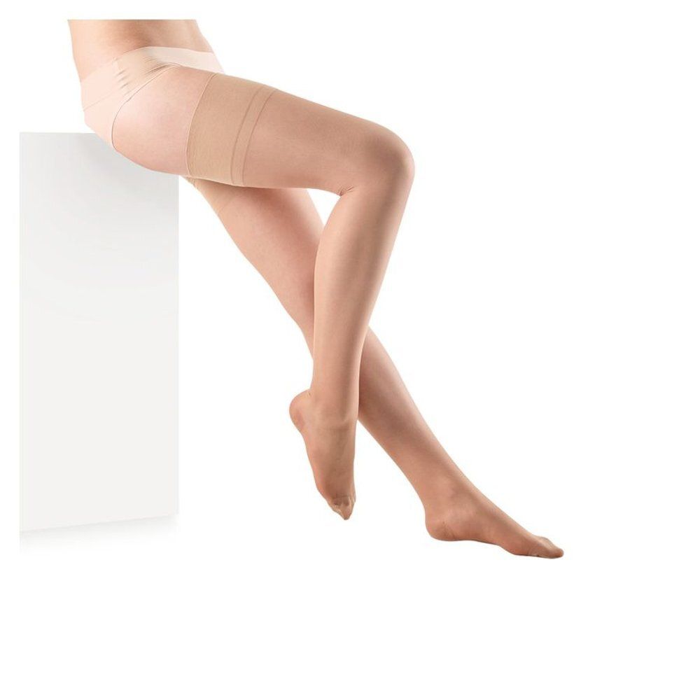 Bas beige. Femme assise sur un piédestal blanc. Fond blanc.
