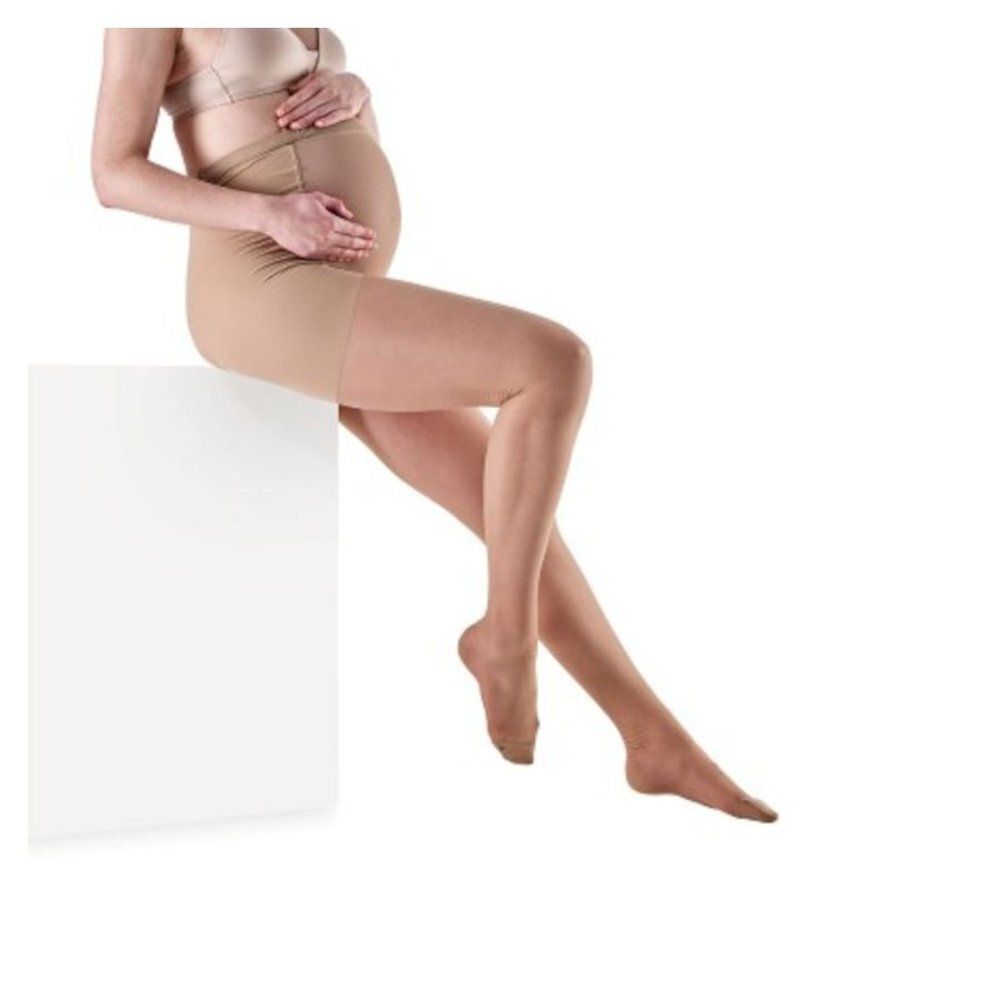 Collant de maternité couleur chair. Soutien abdominal et jambes. Vue latérale, porté par une femme enceinte.