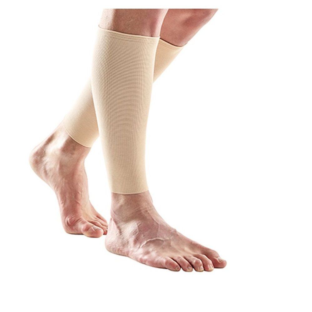 Bas de compression beiges sur une jambe. Montrent les bas sur le pied et la jambe.