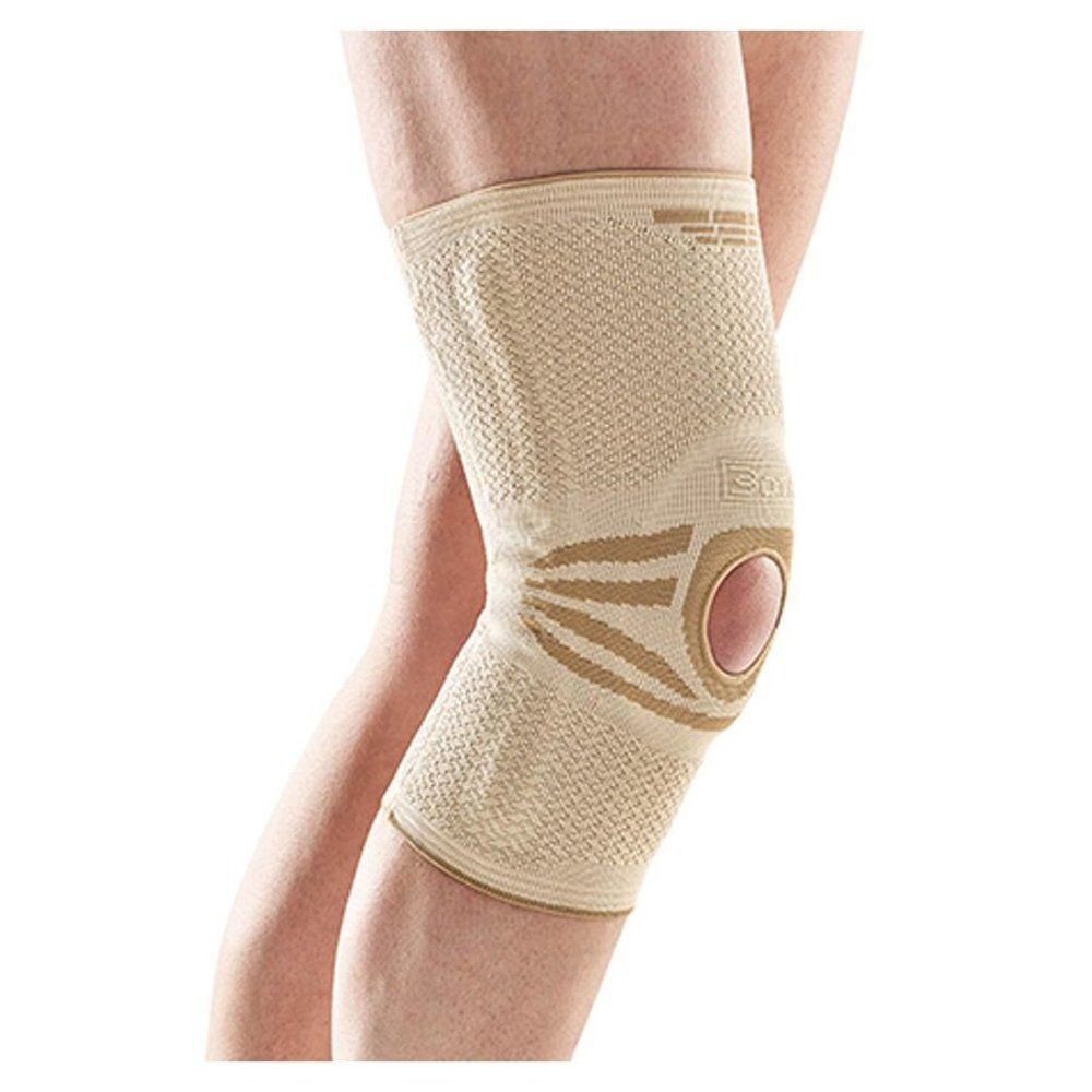 Genouillère beige, avec ouverture pour la rotule. Portée sur une jambe.