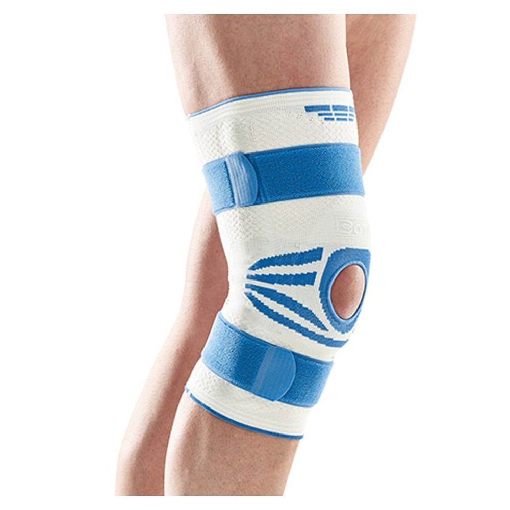 Genouillère blanche et bleue. Avec fermetures velcro et ouverture pour la rotule. Portée sur une jambe.