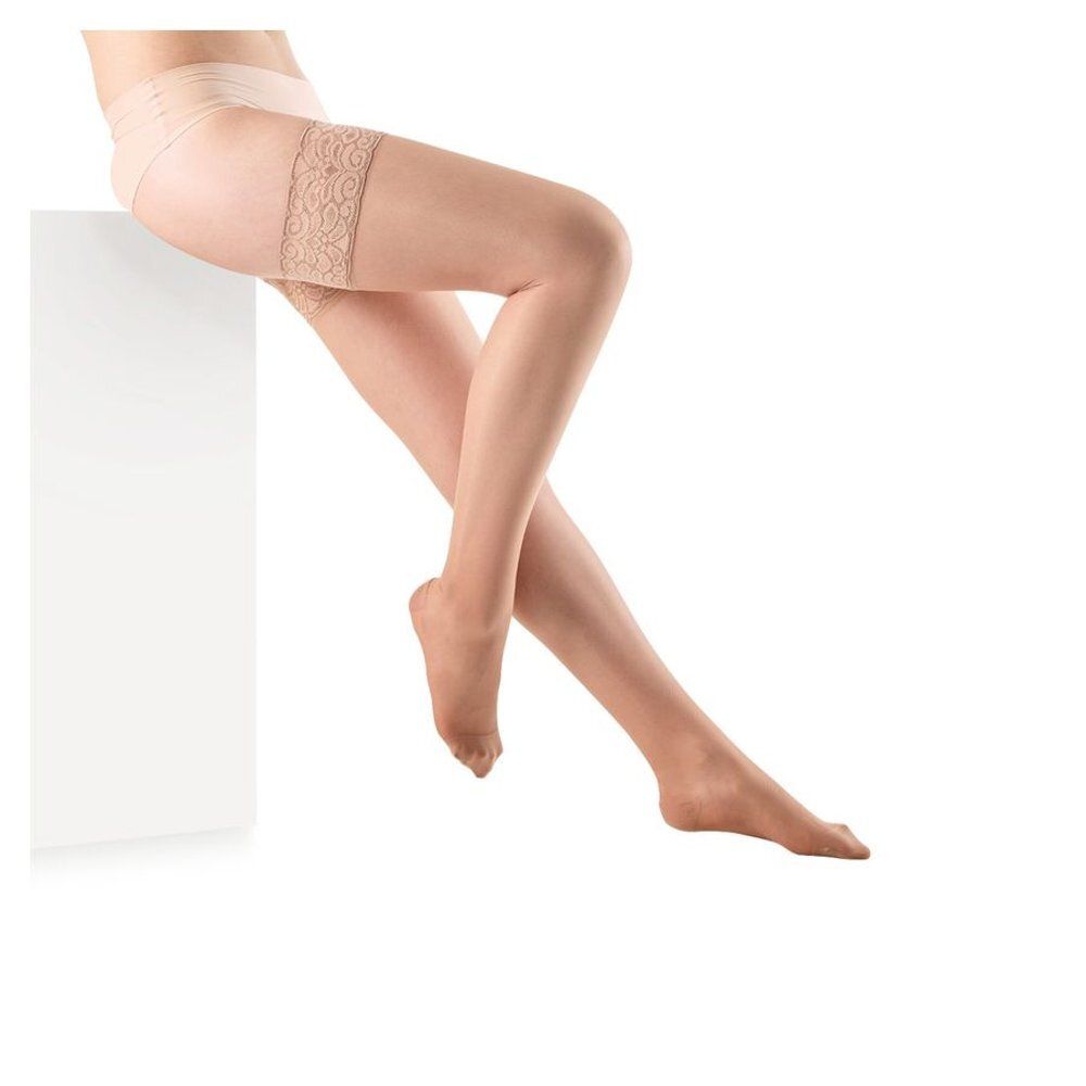 Bas Botalux 140 Stay-Up Skin Color N2. Beige, avec dentelle sur la cuisse. Femme assise sur un bloc blanc.