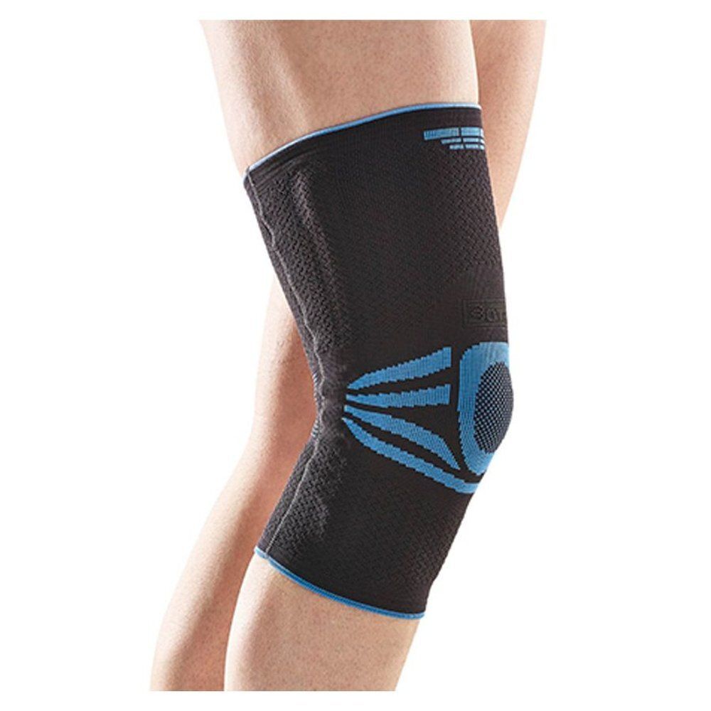 Genouillère noire avec des accents bleus. Portée sur une jambe. Détails visibles.