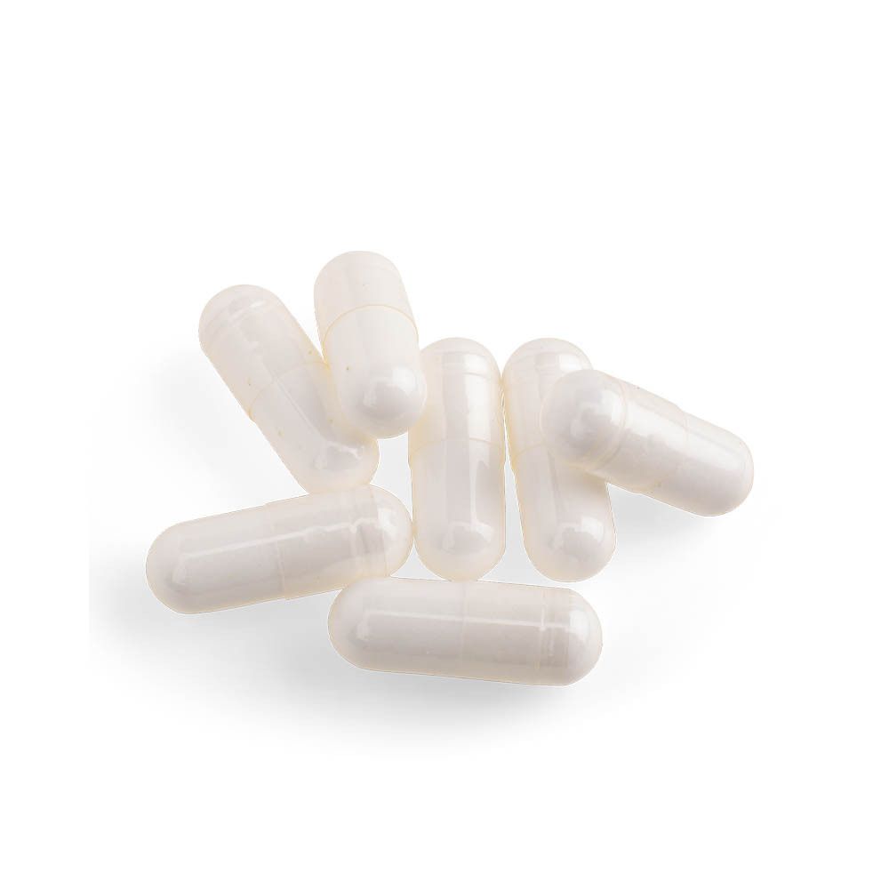 Sept gélules blanches sur fond blanc. Aucune inscription visible.