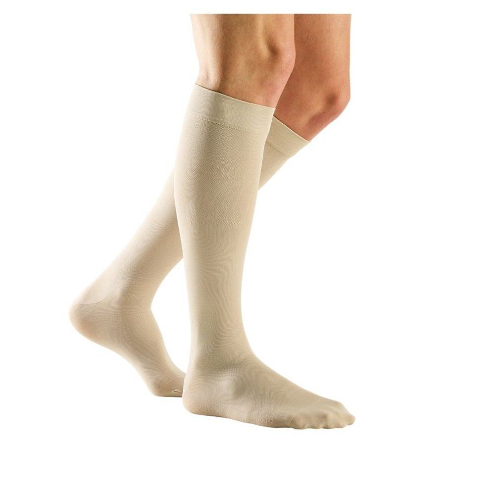 Bas genou beiges. Les bas couvrent le pied et remontent jusqu'au genou. Sur fond blanc.