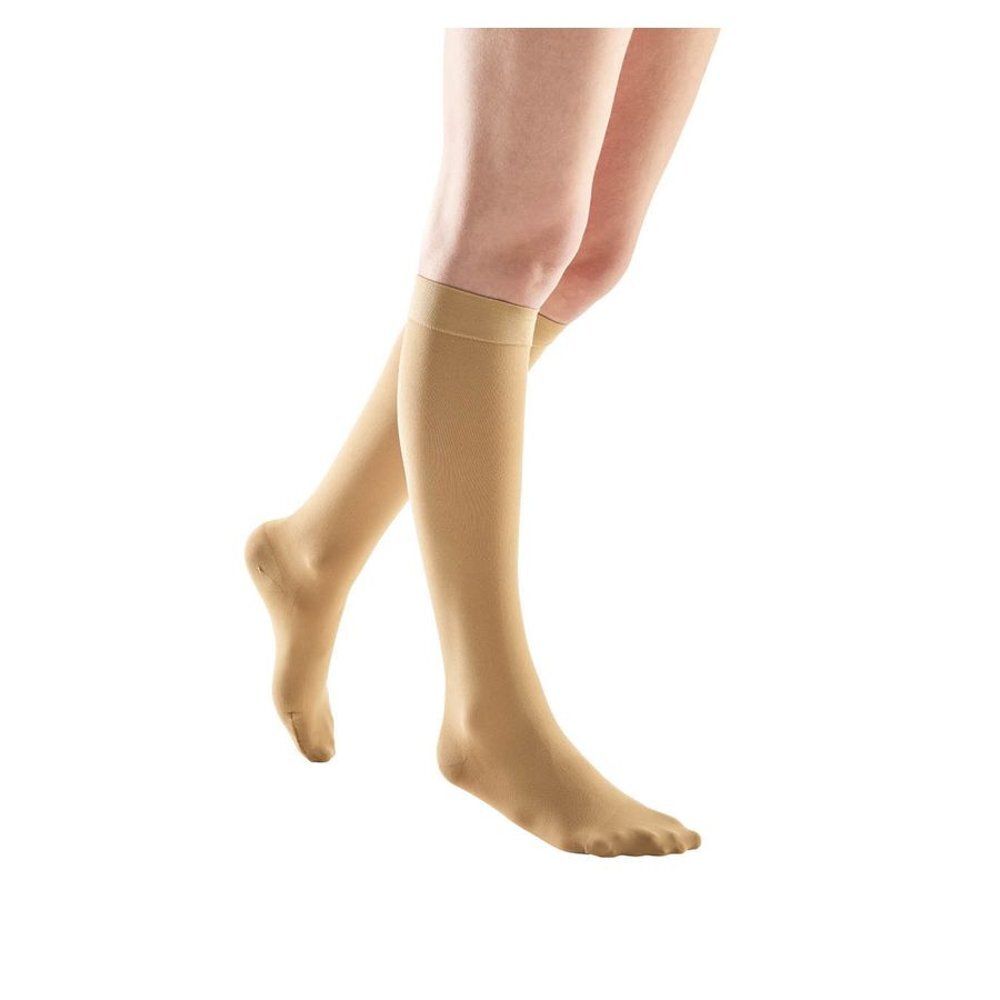 Bas de compression beiges sur une jambe. Bout ouvert. Vue du produit de face.