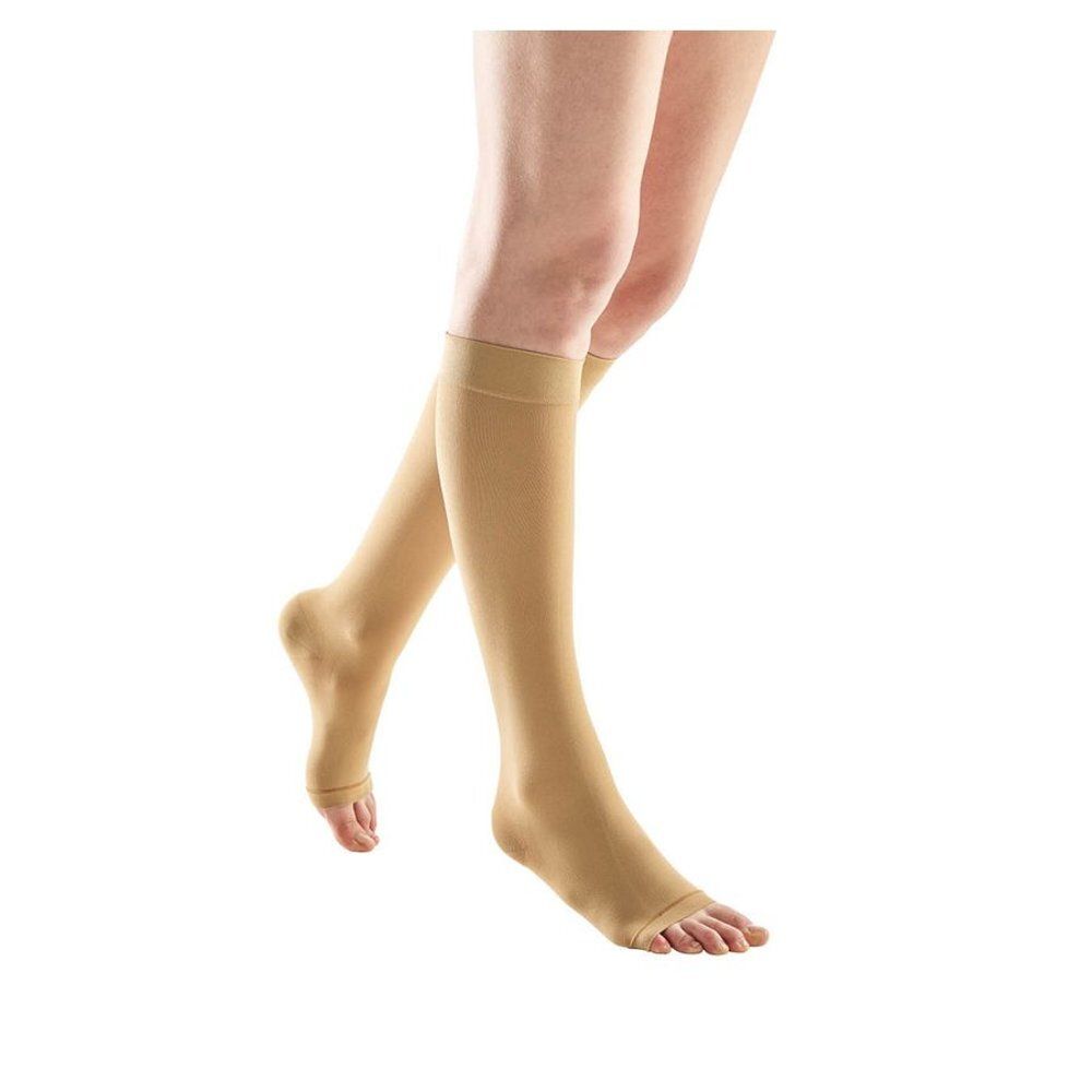 Bas de compression beiges à bout ouvert. Sur fond clair. Vue du produit.