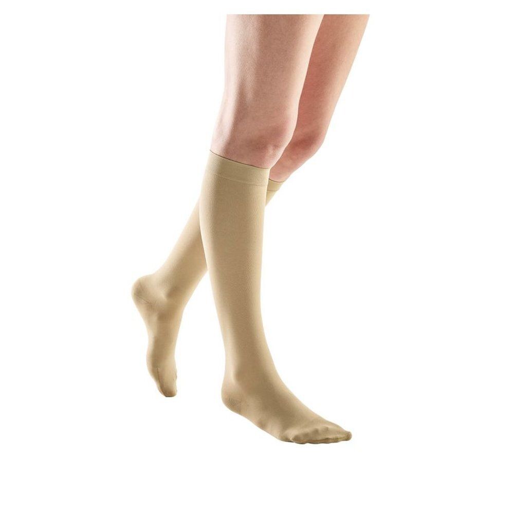 Bas de compression beiges. Vue des jambes. Les bas montent jusqu'au genou.