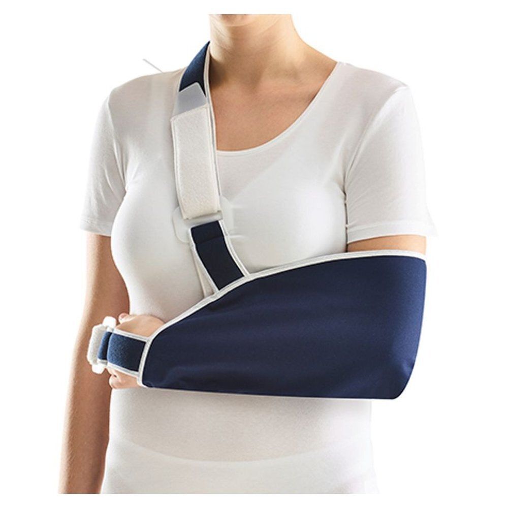 Écharpe de bras bleue, sangle d'épaule blanche, portée par une femme. Le support soutient le bras gauche.