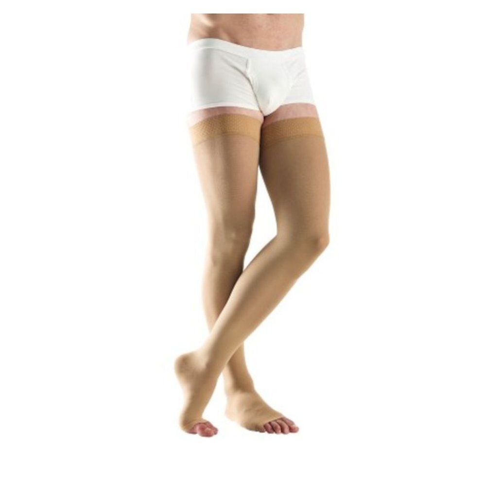 Jambes d'une personne portant des bas de compression. Bas couleur chair, slip blanc.