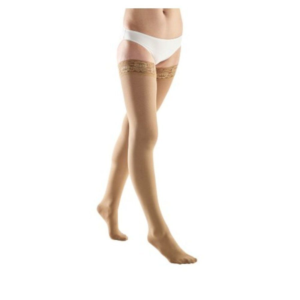 Bas-cuisses beiges avec dentelle sur la cuisse. Le produit est présenté sur fond blanc.
