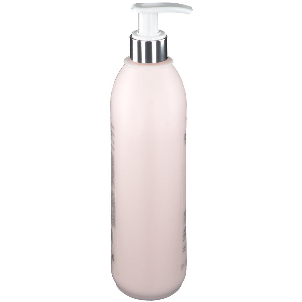 Flacon rose avec pompe, vue latérale. Tête de pompe argentée. Nom du produit non visible.