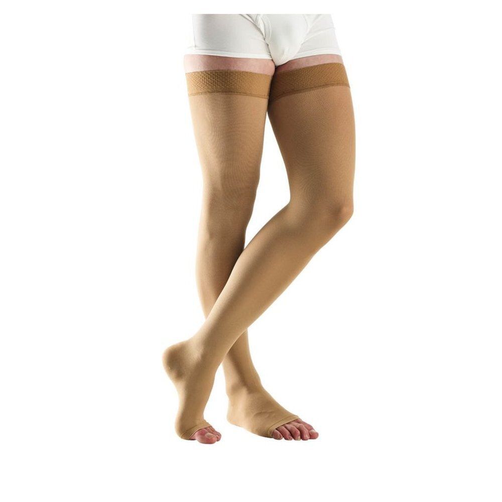 Bas de compression beiges jusqu'à la cuisse. Le bas couvre le pied et une partie de la cuisse.