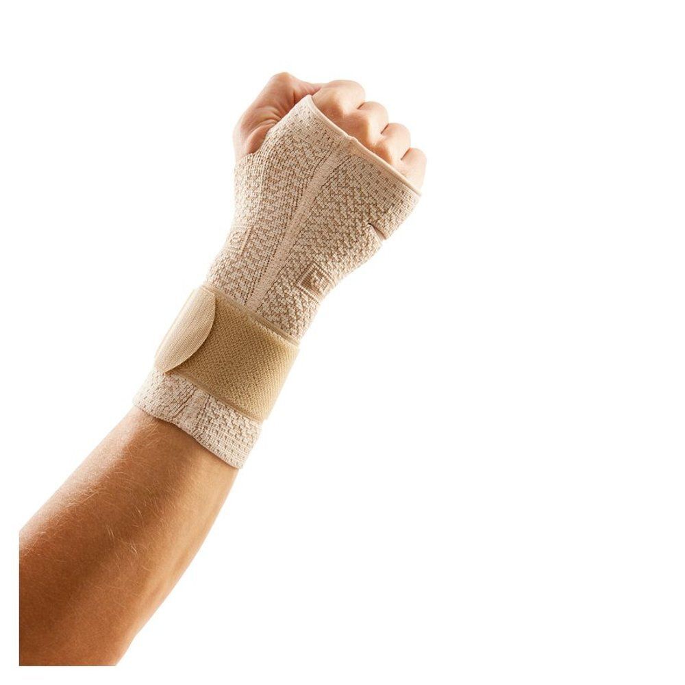Attelle de poignet beige avec fermeture velcro. Main en légère position de poing. Attelle beige au poignet.