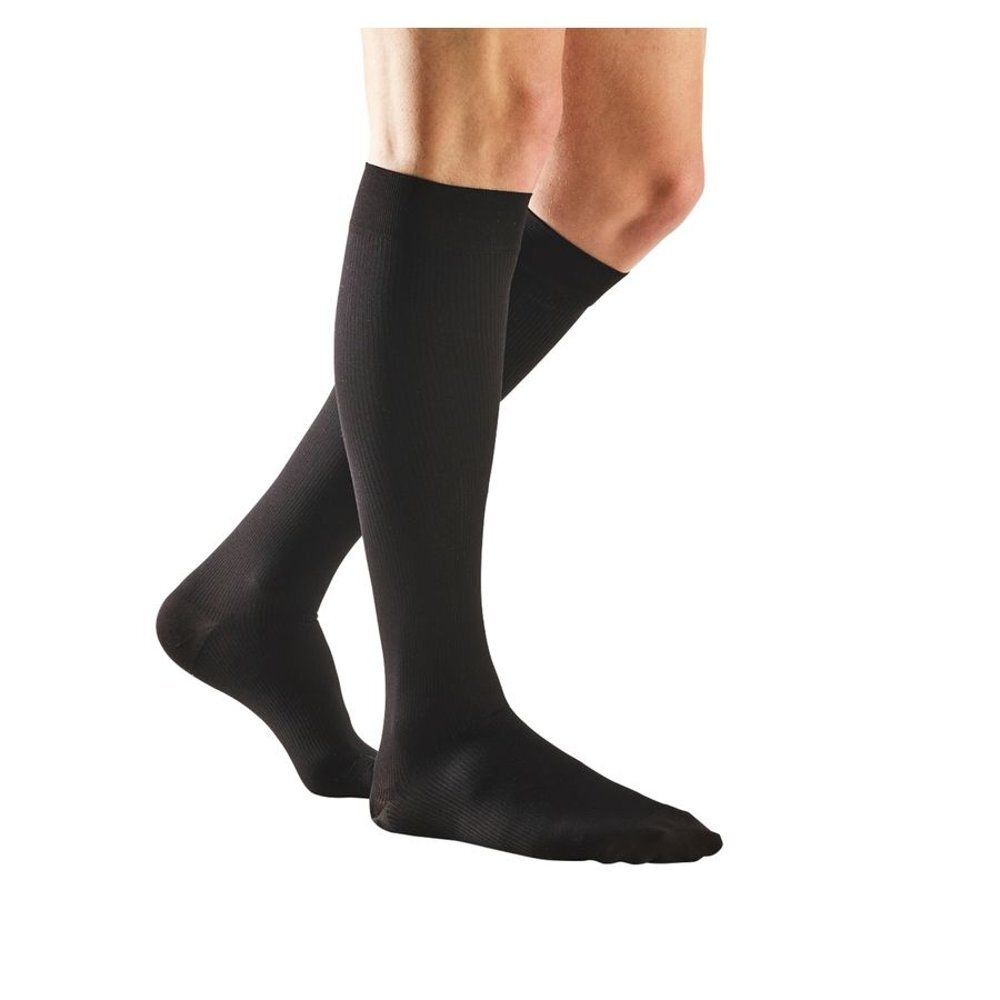Deux bas de compression noirs sur une jambe. Vue de côté. Nom du produit non visible.