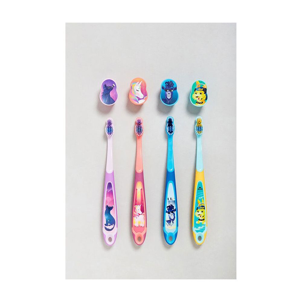 Quatre brosses à dents pour enfants de différentes couleurs. Alignées sur fond blanc. Avec supports.