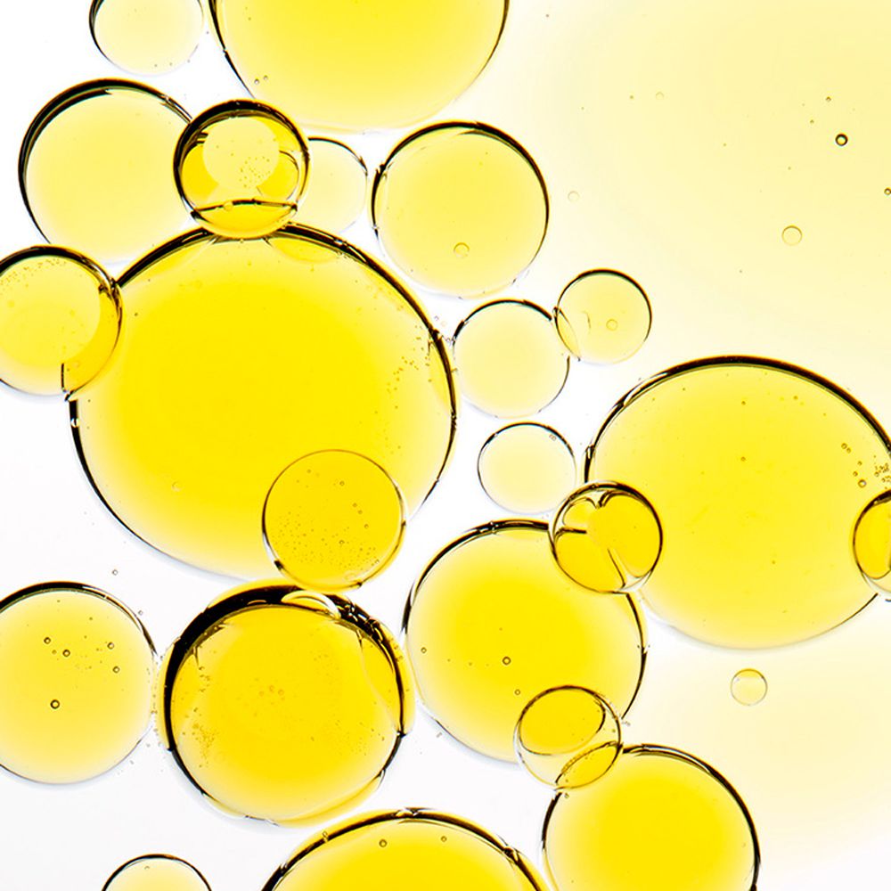 Gros plan de bulles d'huile jaunes sur fond blanc. Différentes tailles et formes.