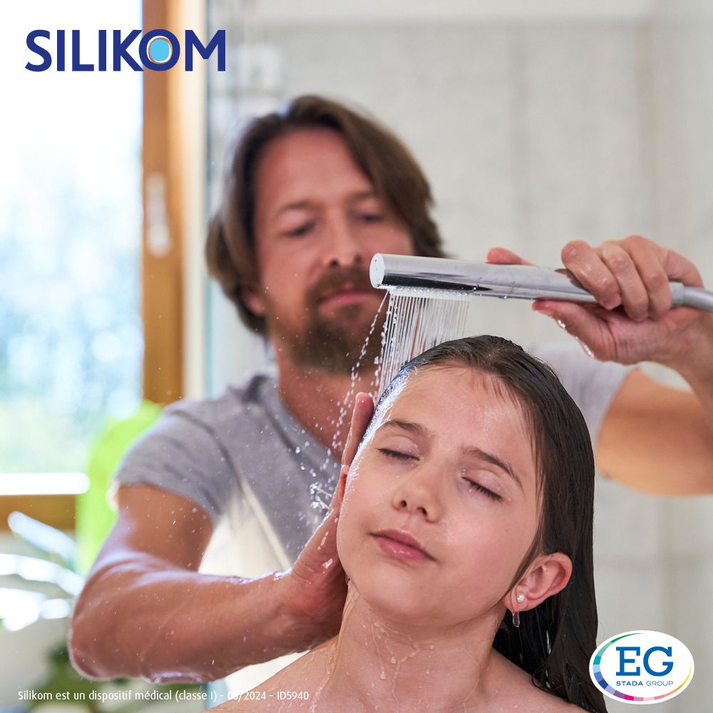 Personne lave les cheveux d'un enfant. Silikom Once Spray Anti-poux.