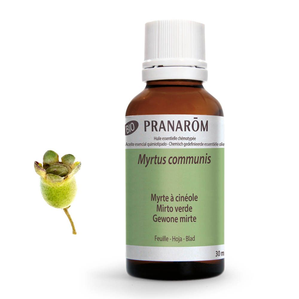 Flacon en verre brun avec bouchon blanc. Étiquette verte et blanche avec nom et marque du produit. Certification BIO. À côté: fruit vert.