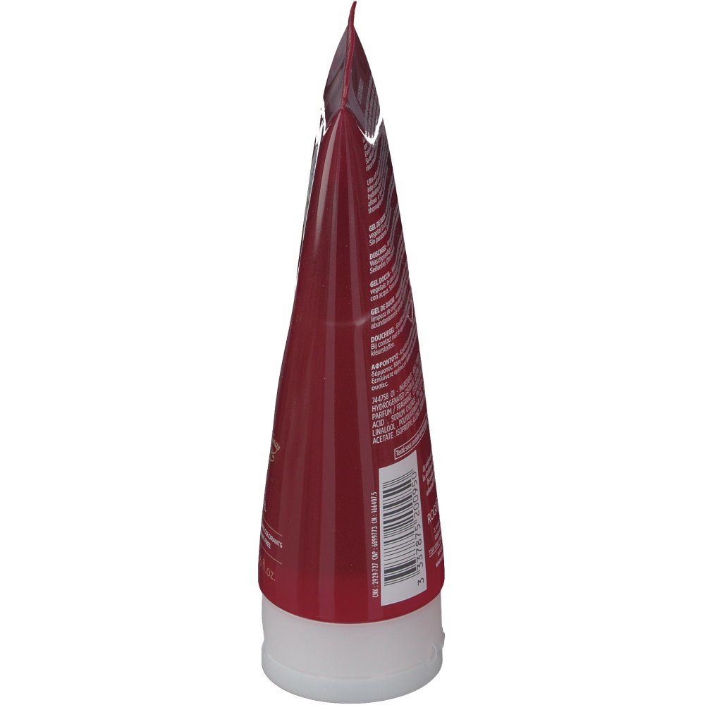 Vue latérale du tube. Tube rouge transparent avec bouchon blanc. Texte au dos.
