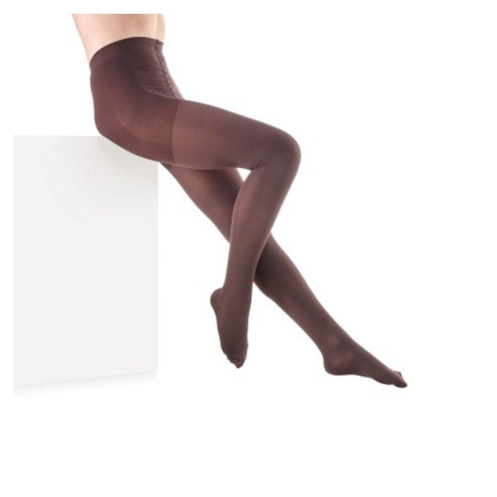 Collants bruns. Personne assise sur un socle blanc. Vêtement pour les jambes.