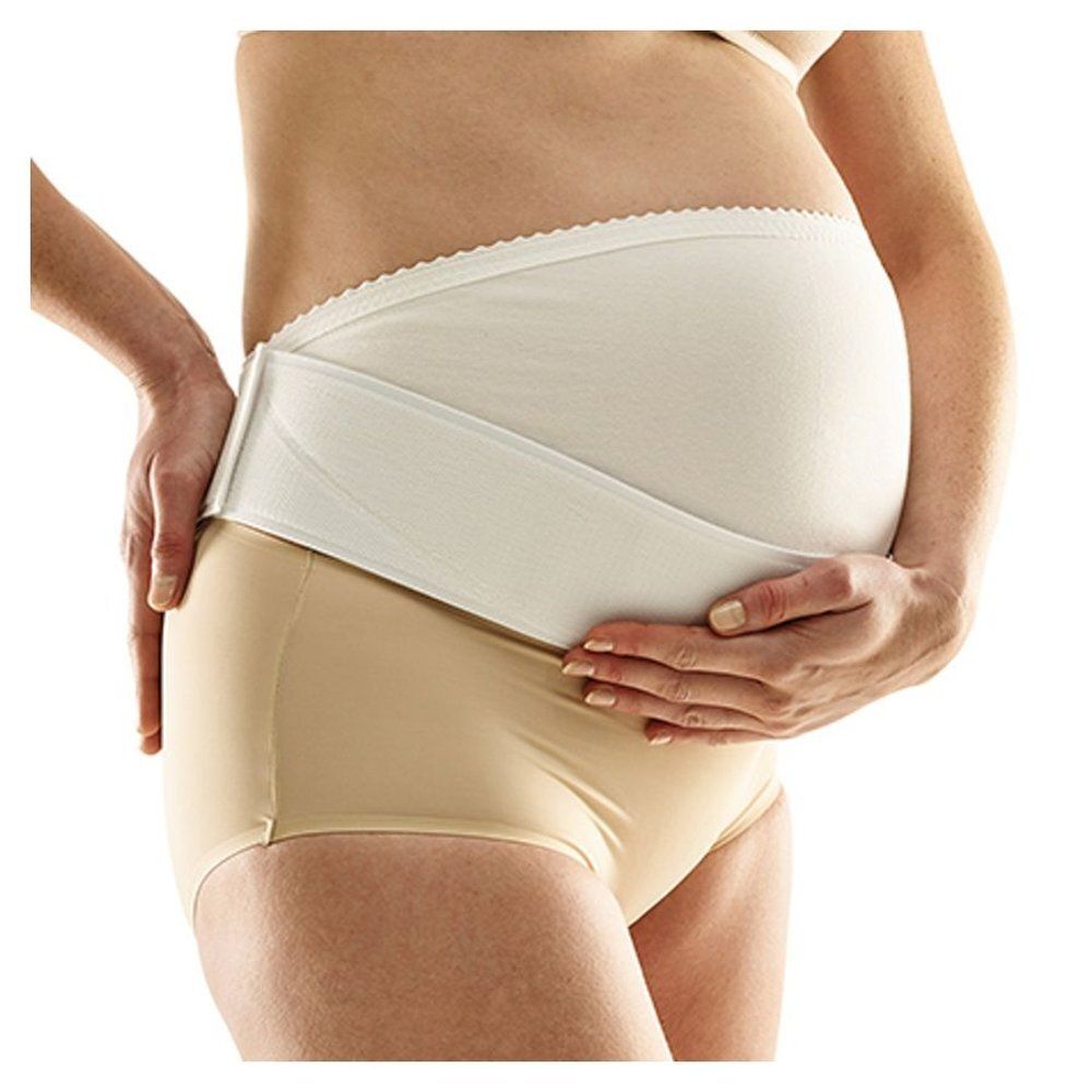 Femme portant une ceinture de grossesse blanche. Sous-vêtements beiges.