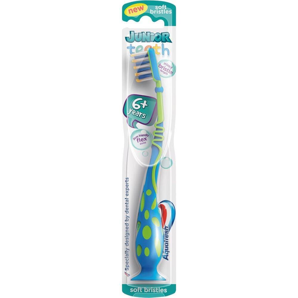 Brosse à dents pour enfants dans son emballage. Brosse bleue et verte à pois bleus. "Junior teeth" et "Aquafresh" visibles.