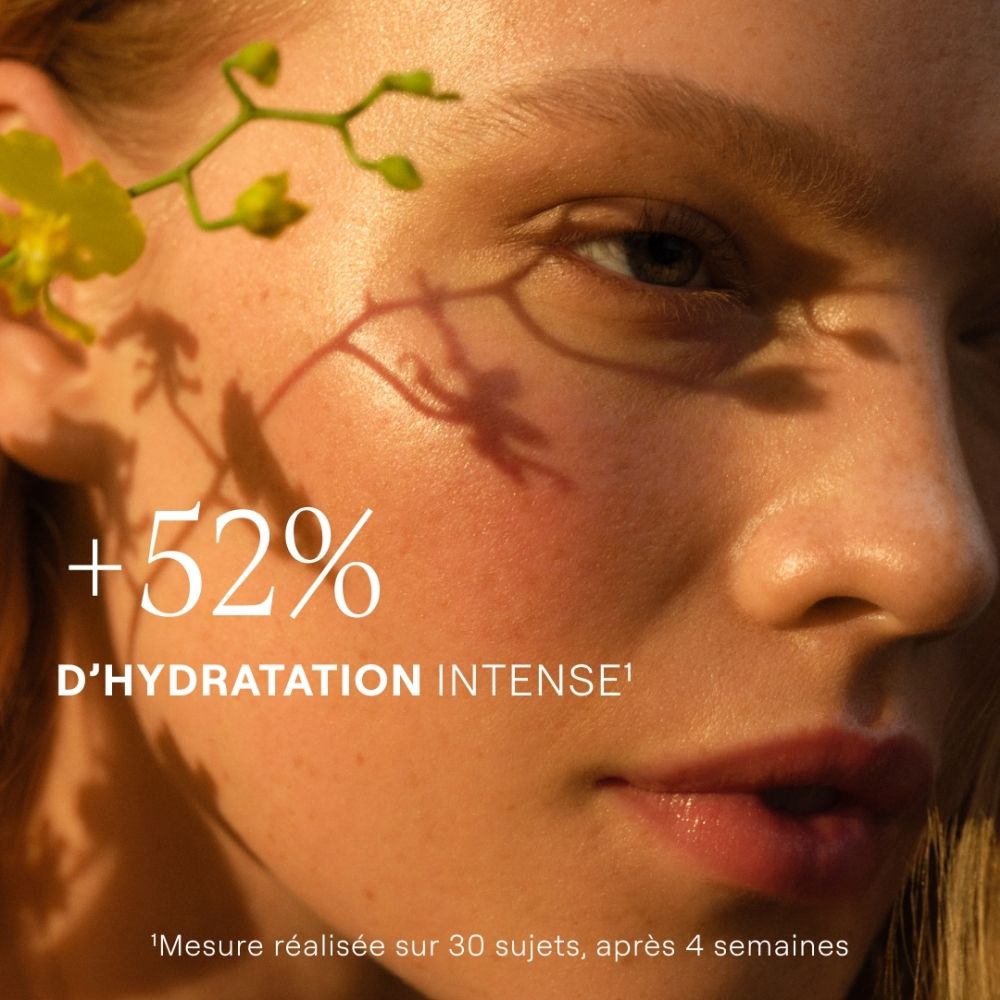Tube verte Weleda Skin Food avec fleurs et gouttes d'huile.