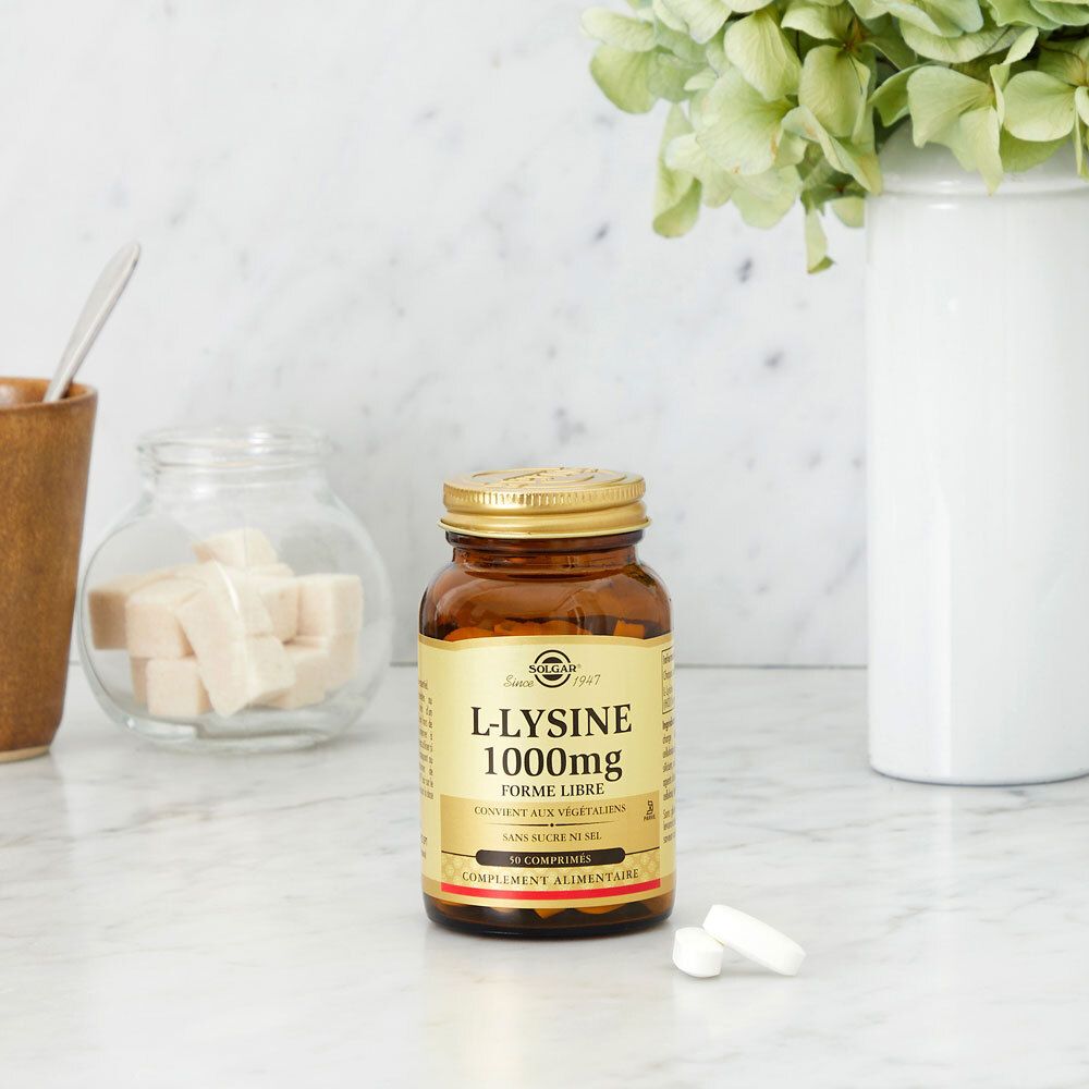 Flacon brun avec bouchon doré sur surface marbrée. Deux comprimés à côté.