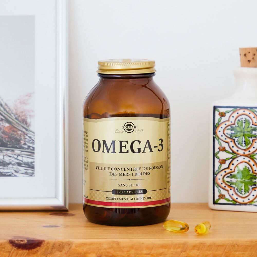 Flacon brun avec bouchon doré. Placé sur une étagère, à côté de décorations.