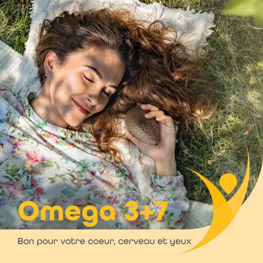 Femme allongée dans l'herbe tenant un avocat. Texte: Omega 3+7. Bon pour le cœur, le cerveau et les yeux.