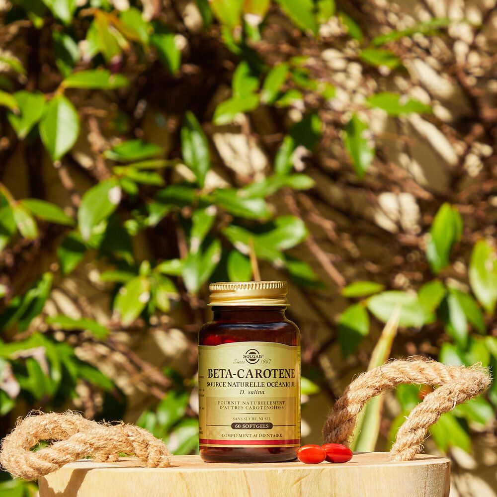 Flacon brun sur bois, entouré de feuilles et décoration de cordes.