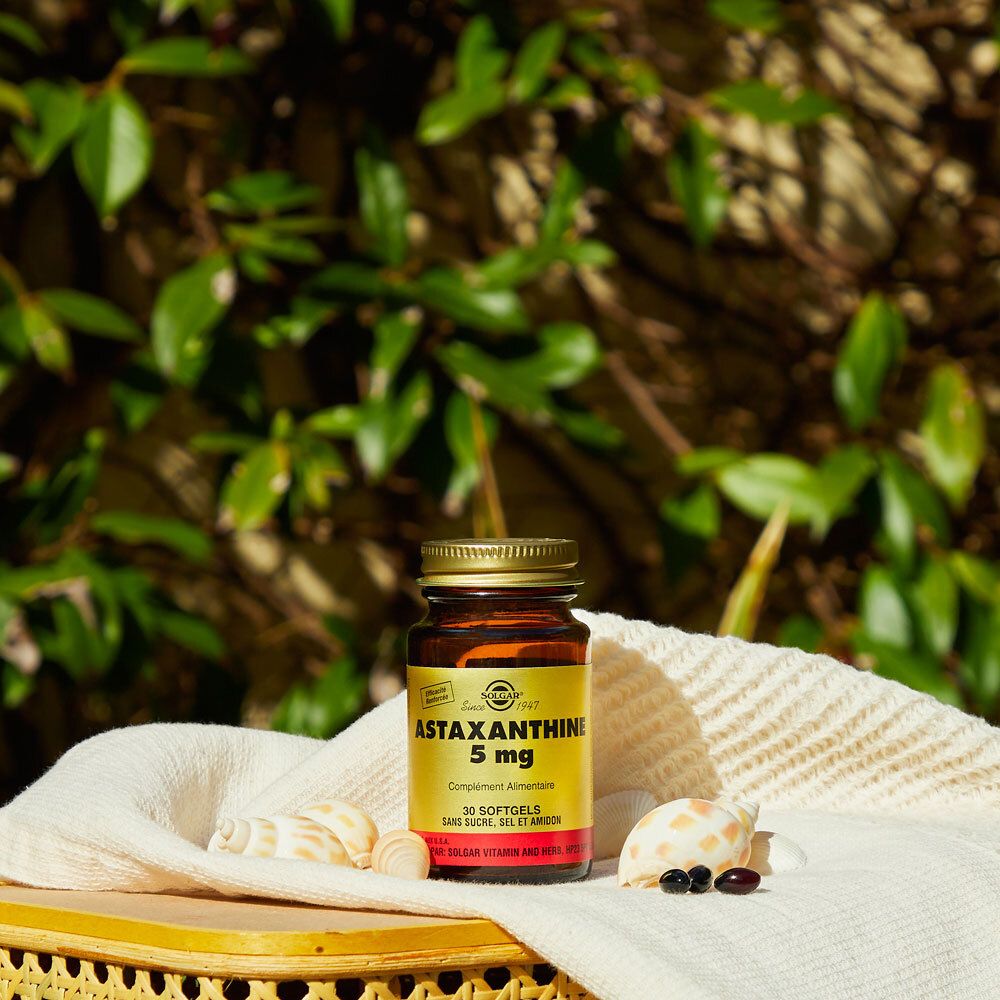 Flacon en verre avec Astaxanthine 5 mg. Sur un panier avec décoration.