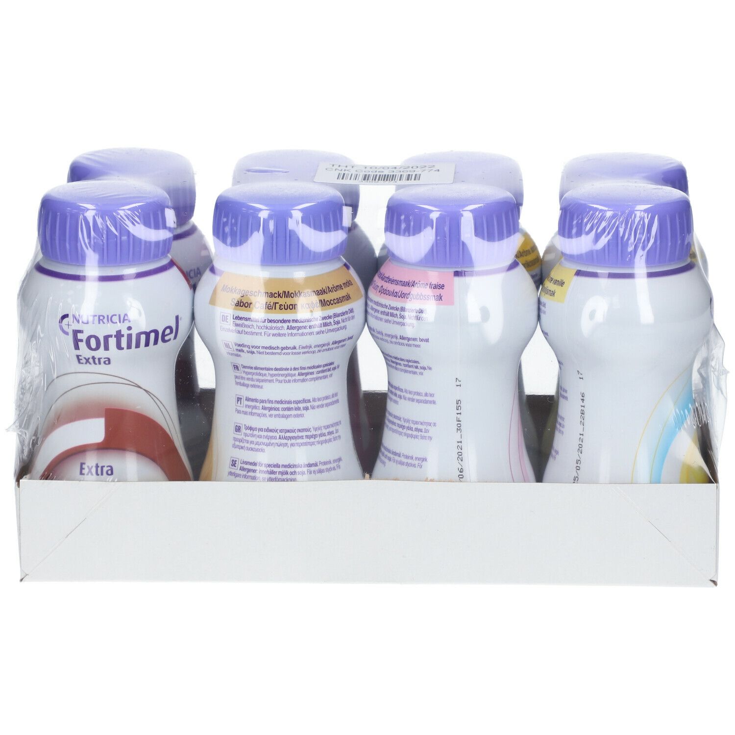 Emballage de bouteilles. Inscription 'Fortimel extra'. Bouteilles avec bouchons violets et étiquettes blanches. Emballé dans du film plastique.