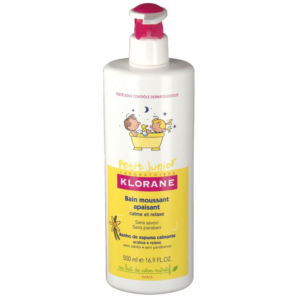 Flacon blanc avec pompe rose. Étiquette jaune avec texte et illustrations. Inscription : Klorane Petit Junior, bain moussant apaisant.
