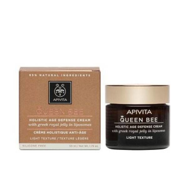 Crème et emballage. Inscription : Apivita Queen Bee, Holistic Age Defense Cream. Pot en verre brun, couvercle doré.