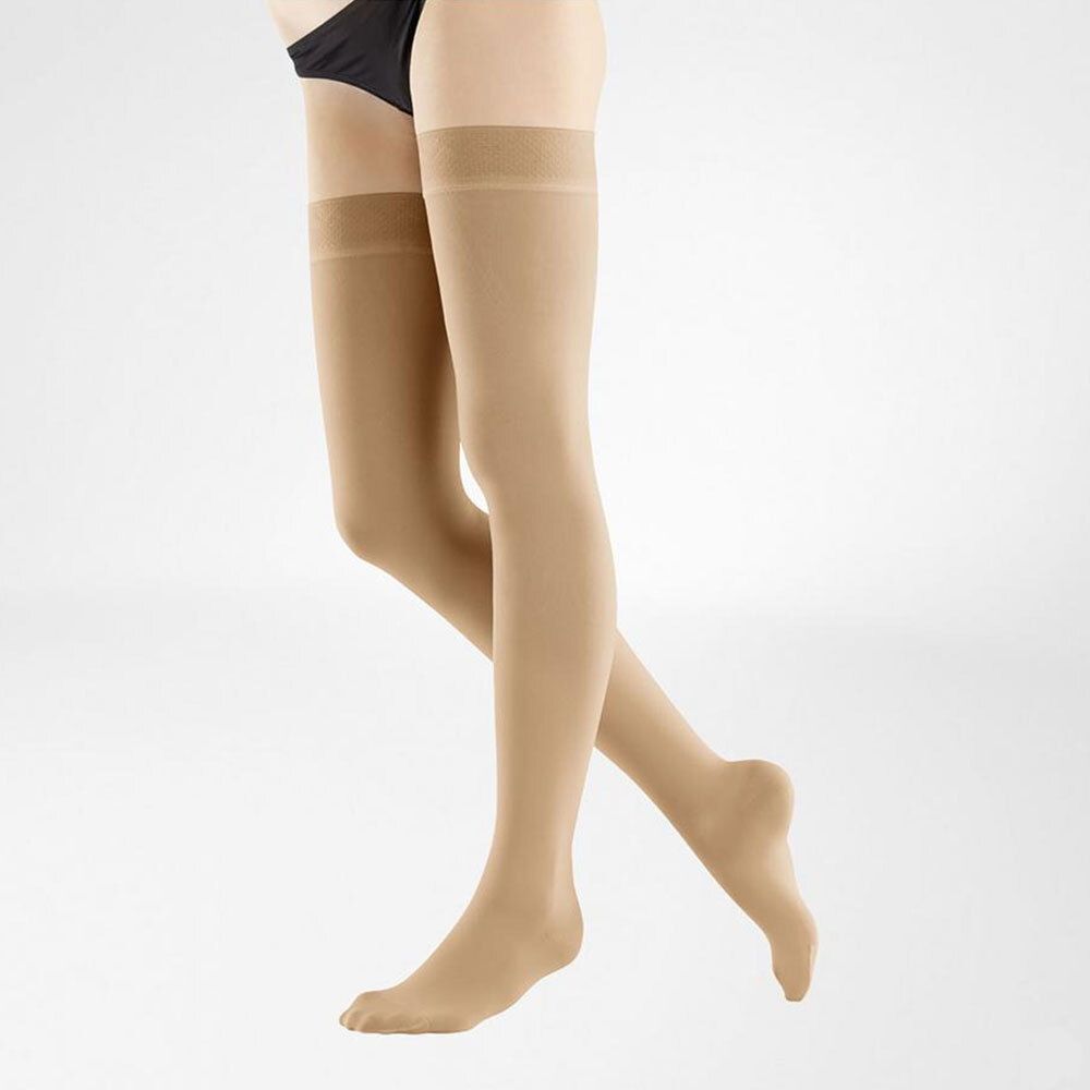 Bas de compression beiges, hauteur genou. Pointe ouverte. Couleur chair. Sur fond clair.