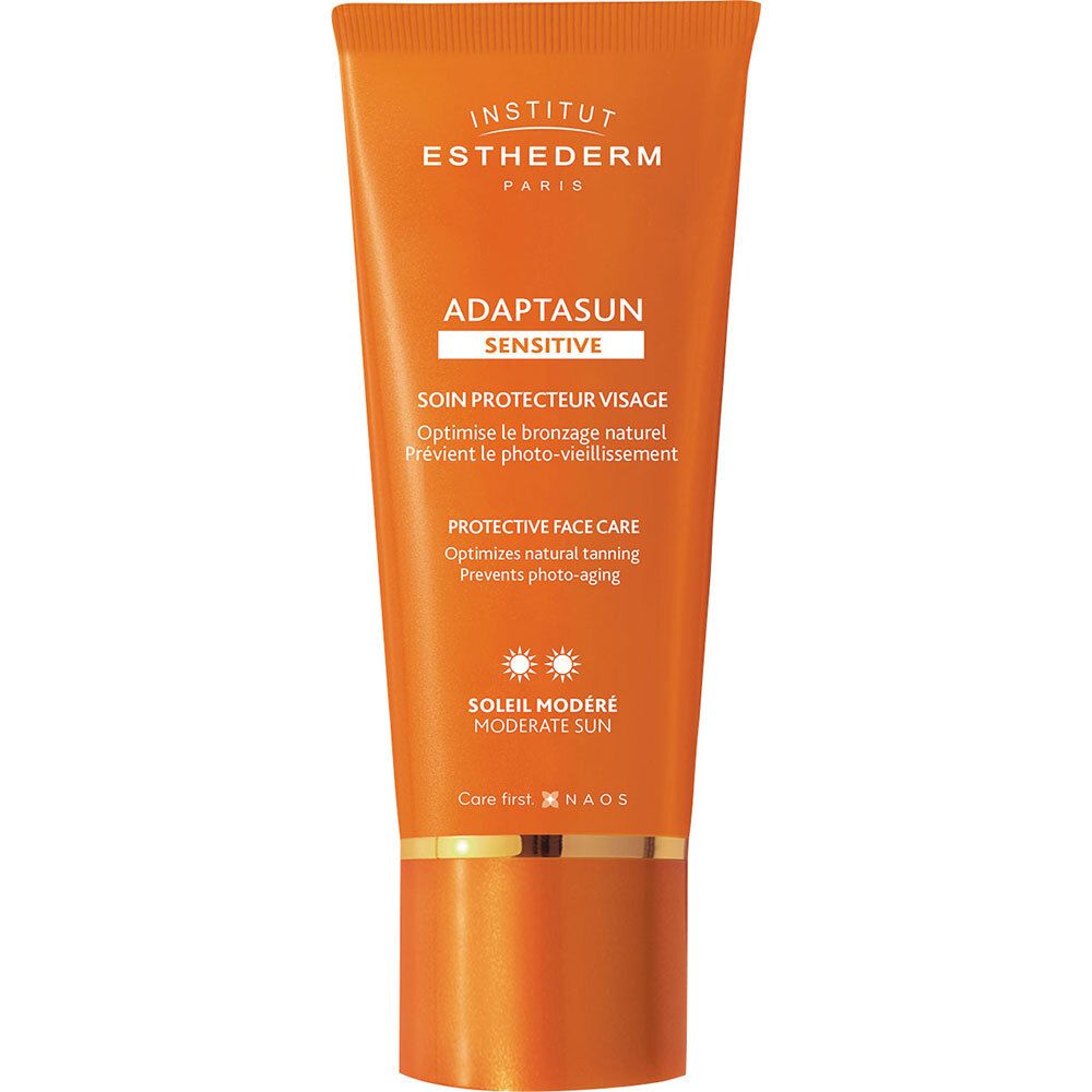 Tube orange de crème solaire. Inscription: Adaptasun Sensitive, Protective Face Care. Marque: Institut Esthederm.