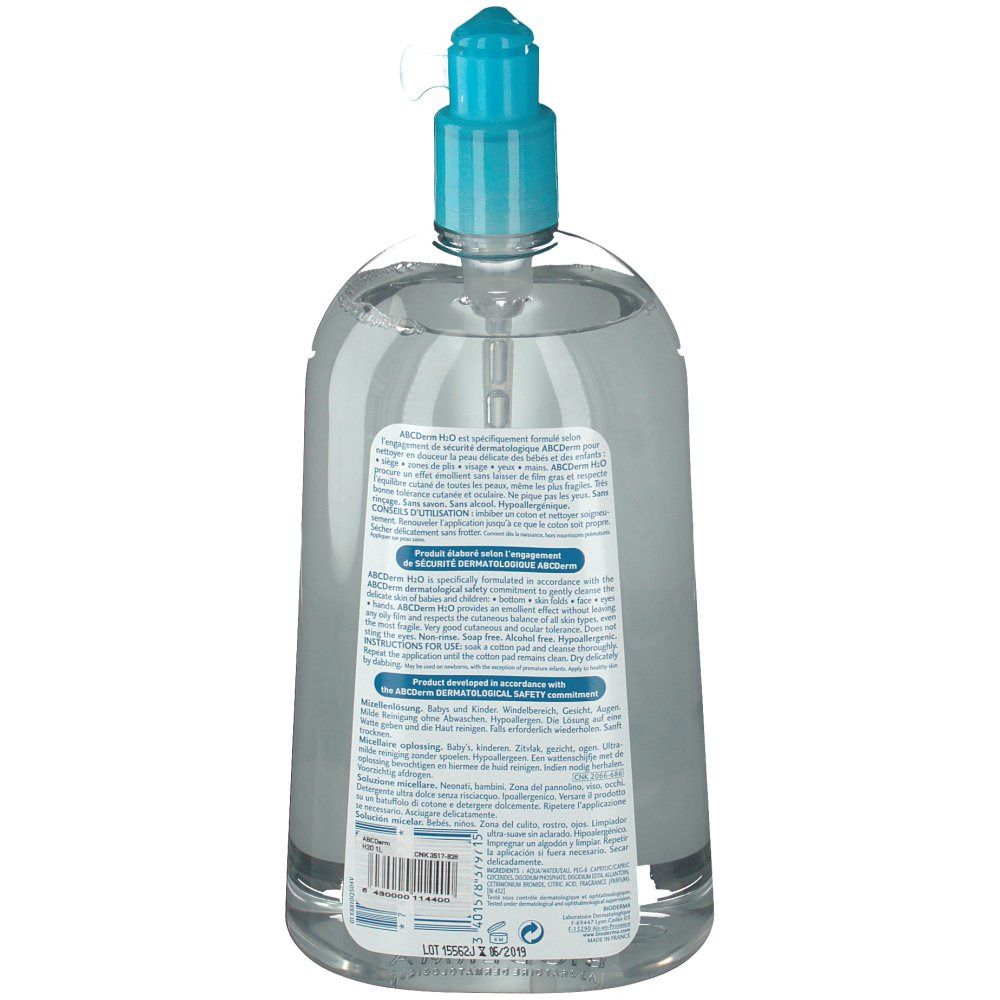 Vue arrière d'un flacon transparent avec bouchon pompe bleu. Texte sur l'étiquette, informations sur le produit et code-barres.