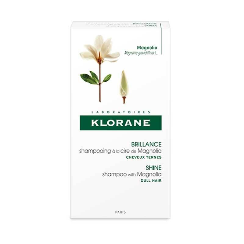 Emballage de shampooing Klorane à la cire de magnolia. Boîte blanche avec informations et fleur de magnolia.