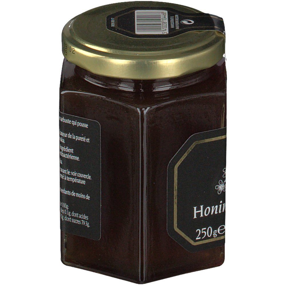 Pot de miel hexagonal avec étiquette noire et texte. Couvercle doré. Inscription 'Honing' et '250ge'.
