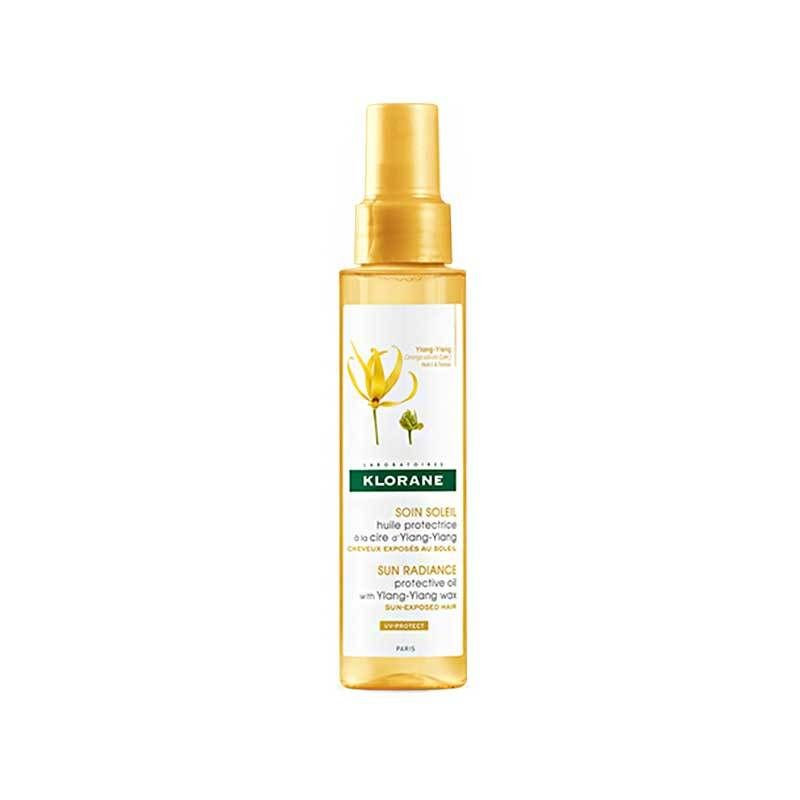 Flacon spray jaune avec bouchon doré. Étiquette avec nom du produit et illustration florale. Marque : KLORANE.