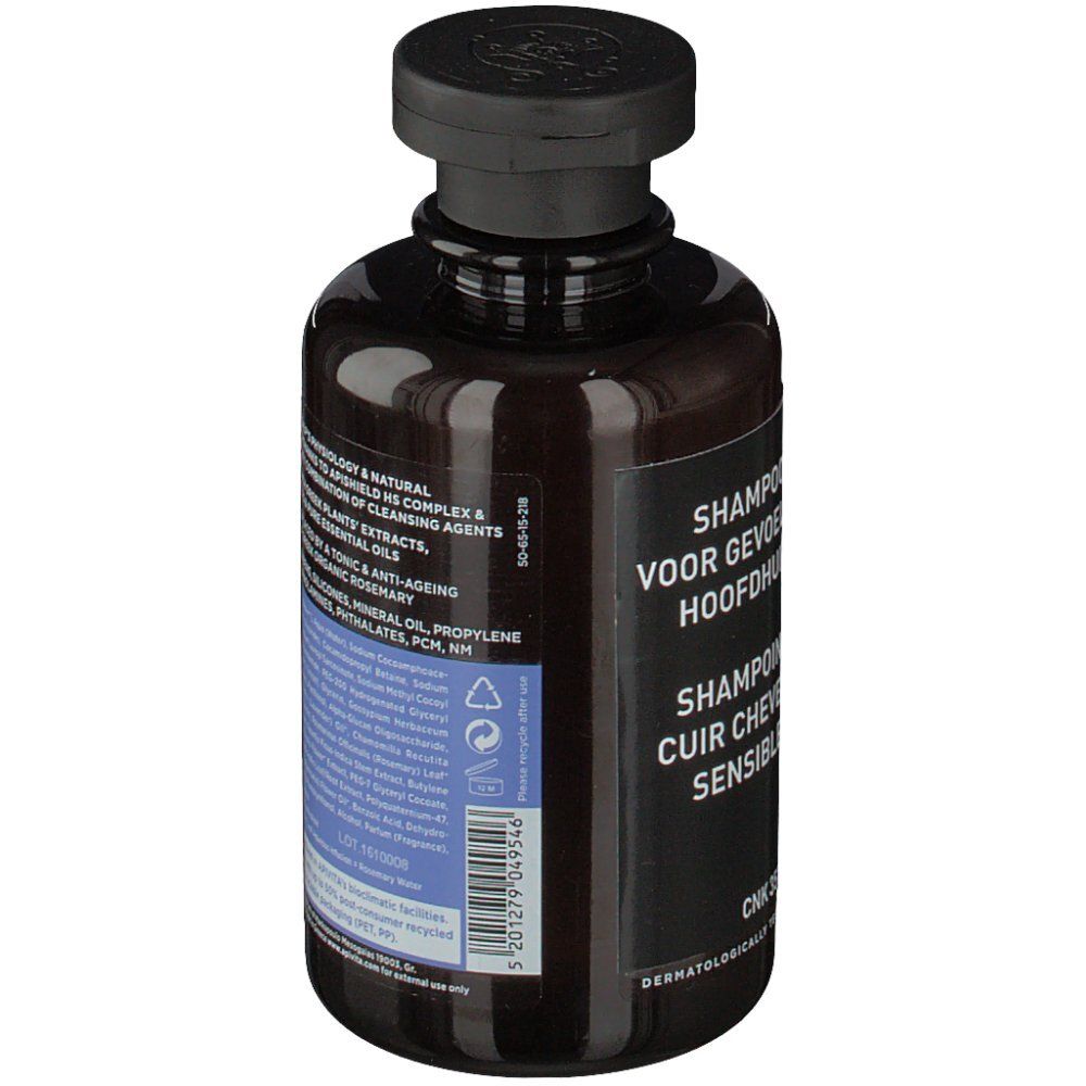 Dos du flacon marron. Étiquette noire avec texte multilingue. Testé dermatologiquement.