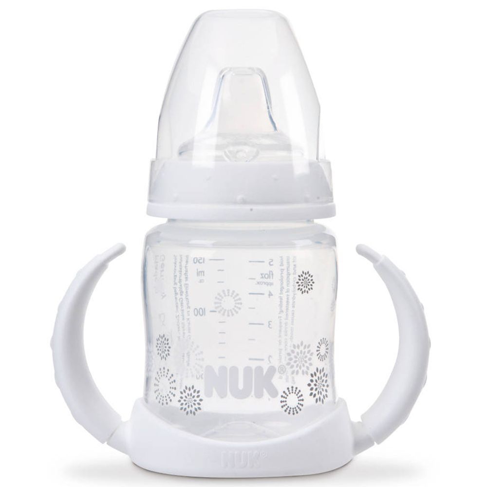 Biberon d'apprentissage NUK blanc avec poignées et graduation. Tétine et couvercle en plastique transparent.